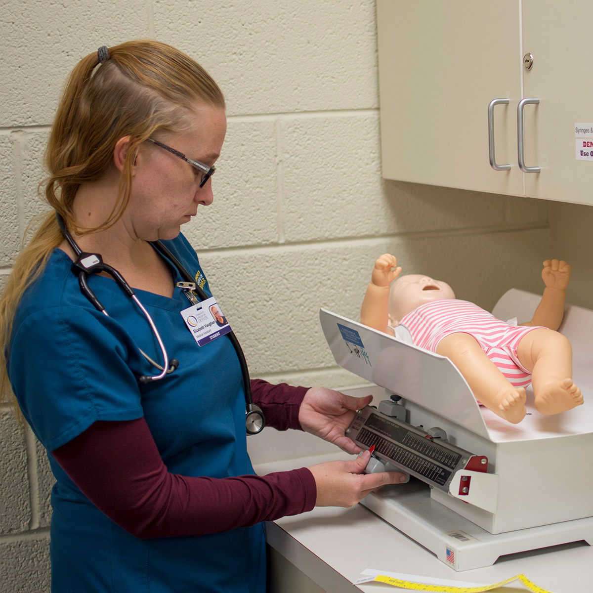 lol博彩 Medical Assistant student weighing a baby dummy