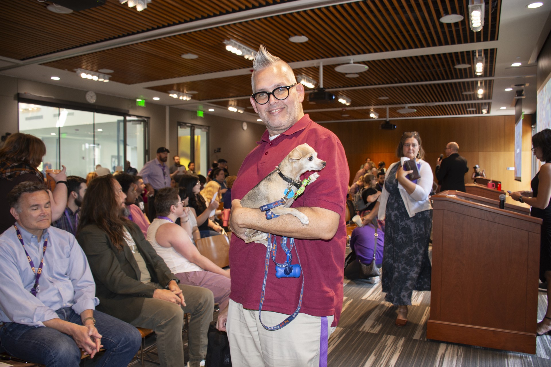 faculty and staff in background with teacher holding little puppy
