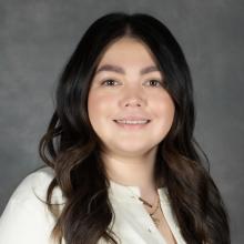 woman with long brunette hair wearing white top