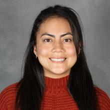 Woman with long brown hair wearing red sweater