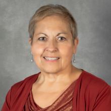 Woman with short blond hair wearing a red top